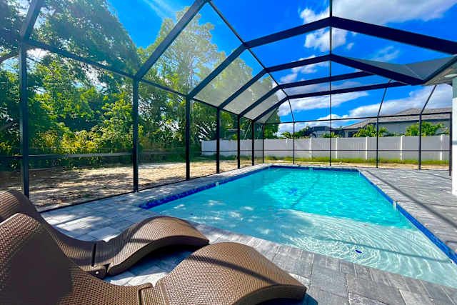 Screened heated pool and loungers in the fenced yard at 5206 Pocatella Ct, Cape Coral